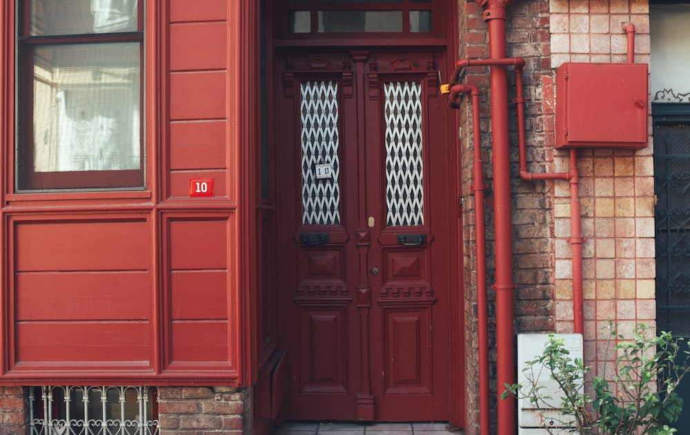 red wooden door with black steel gate