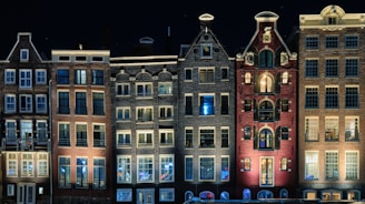 Edificio marrone in cemento durante la notte ad Amsterdam, nei Paesi Bassi