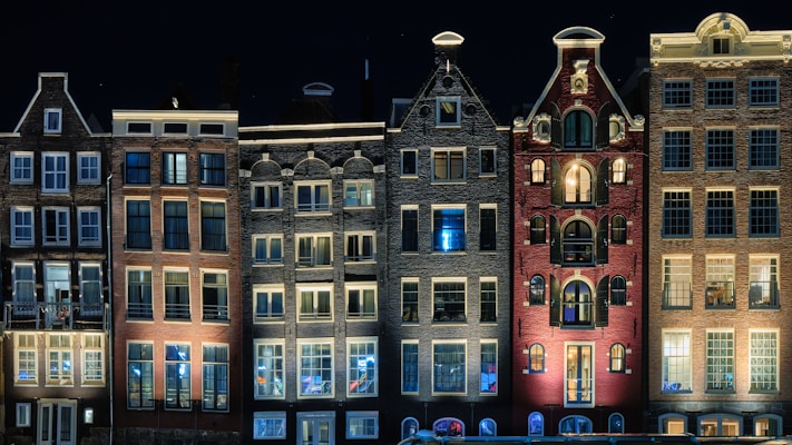 Edificio marrone in cemento durante la notte ad Amsterdam, nei Paesi Bassi