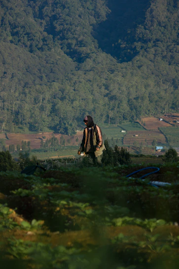 Portrait of Alfredo Garcia standing in a lush green field under a clear sky.