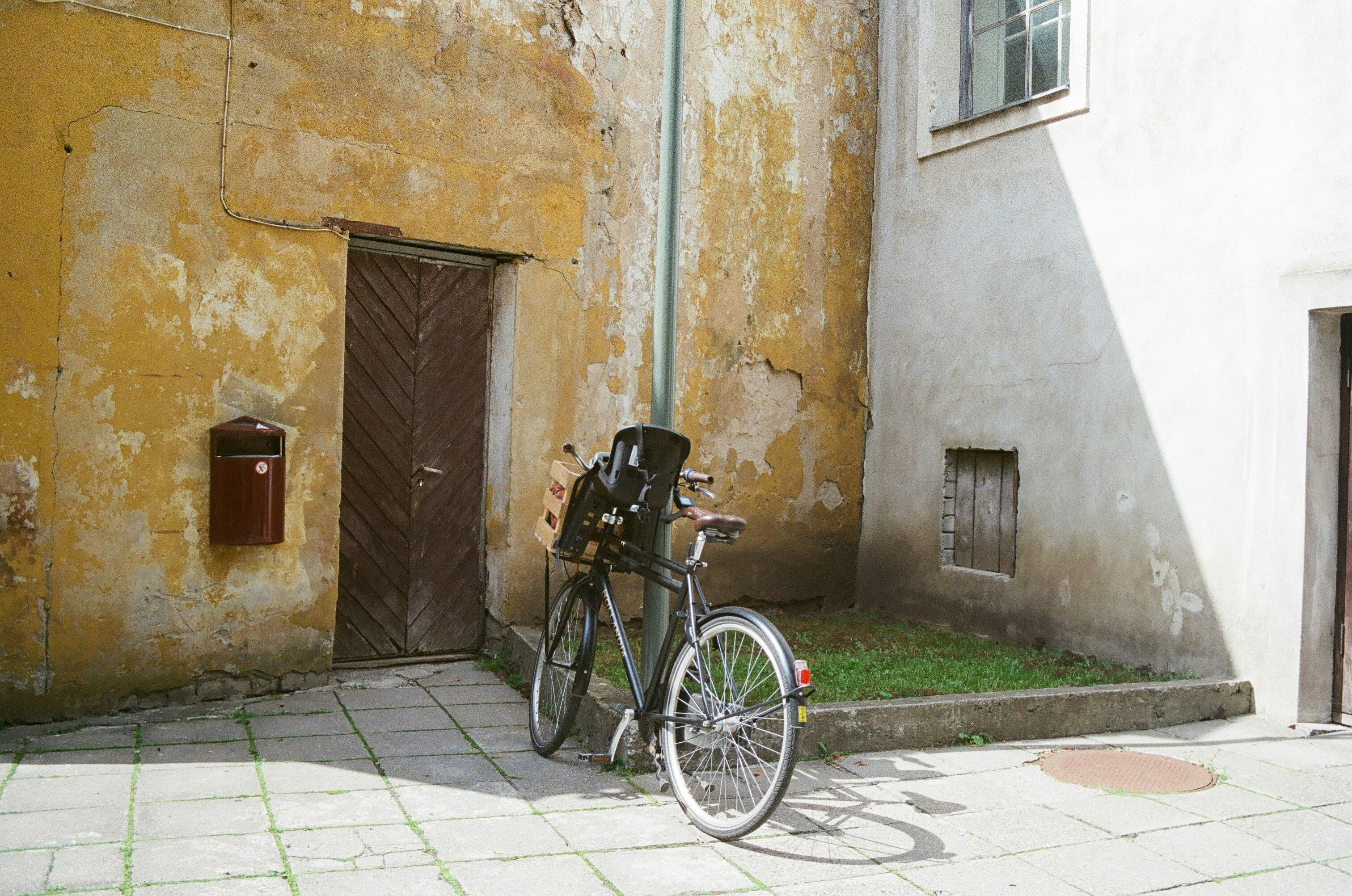 black bicycle parked beside brown concrete wall