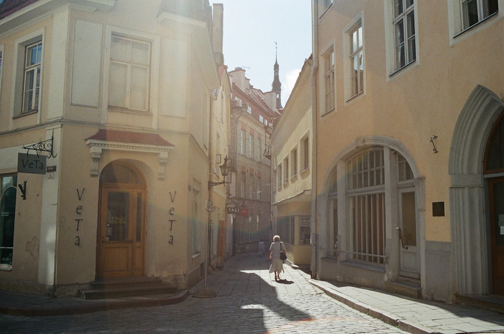 woman in white long sleeve shirt walking on street during daytime