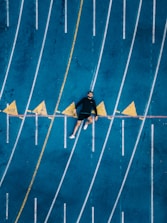 un jeune athlete allongé sur une piste de course