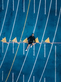 un jeune athlete allongé sur une piste de course