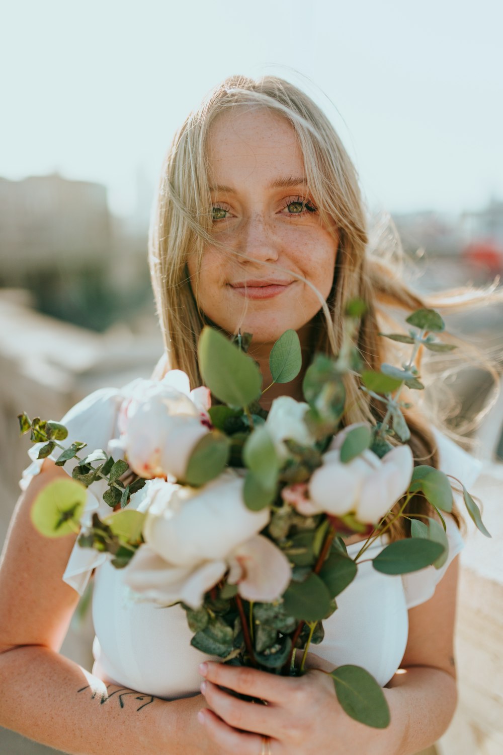 Mujer sosteniendo flores blancas durante el día