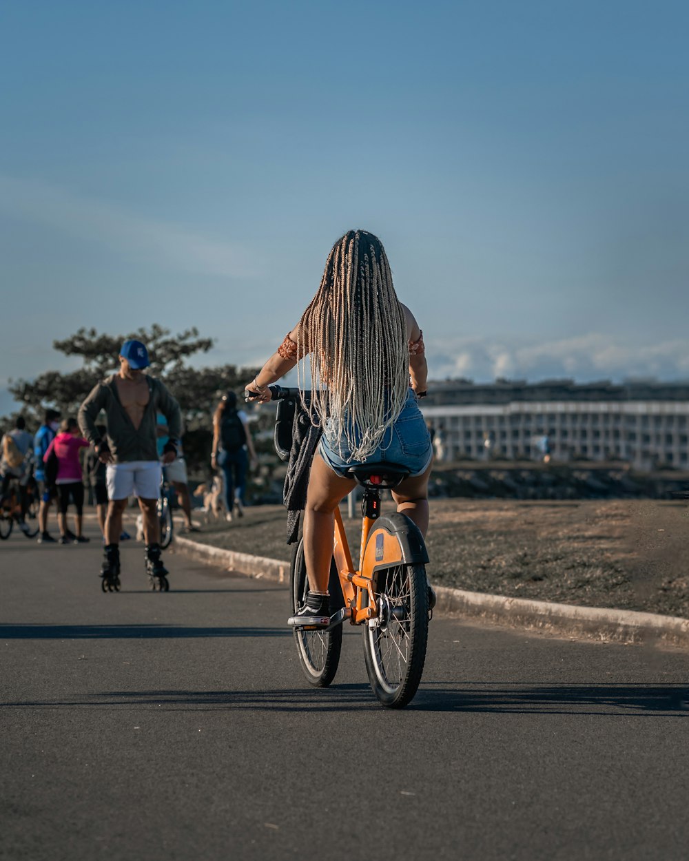 woman in black and white striped long sleeve shirt riding bicycle on road during daytime