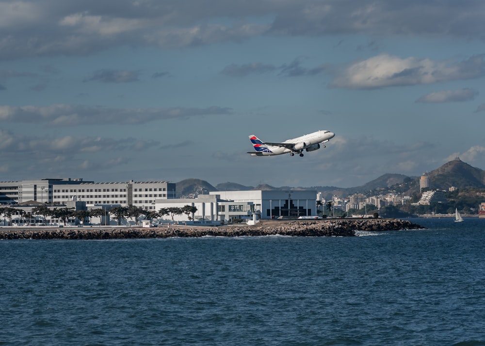 white passenger plane flying over city skyline during daytime