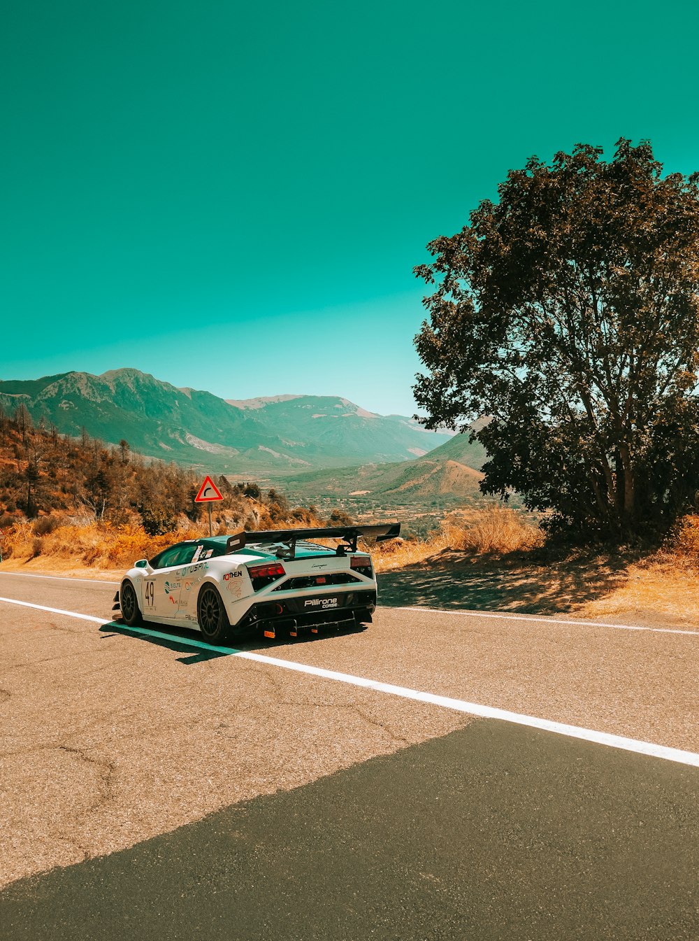 white and black chevrolet camaro on road during daytime