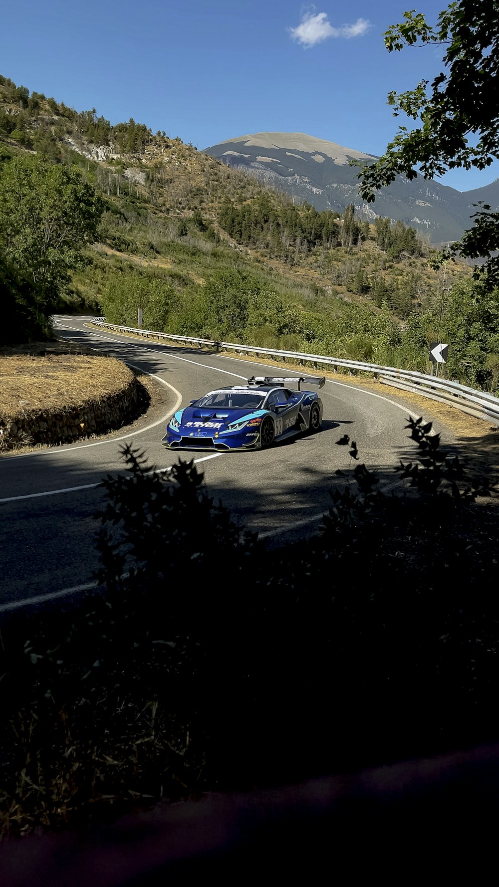 blue and white racing car on track during daytime