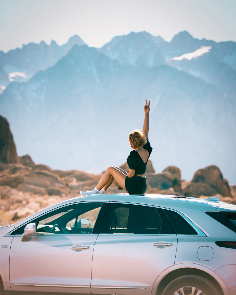 a woman is sitting on top of a car