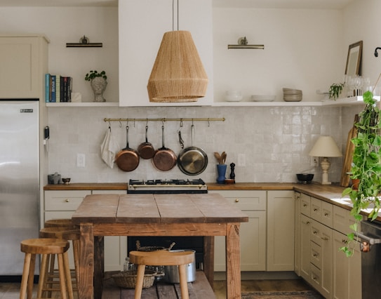 brown wooden seat beside white wooden kitchen cabinet