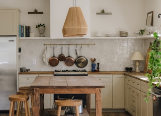 brown wooden seat beside white wooden kitchen cabinet