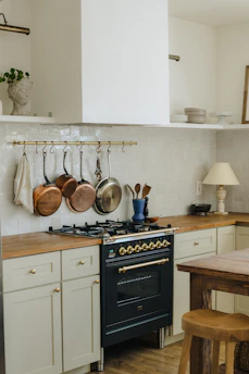 Elegant kitchen with dark Viking cabinets featuring intricate paneling and vintage brass handles.