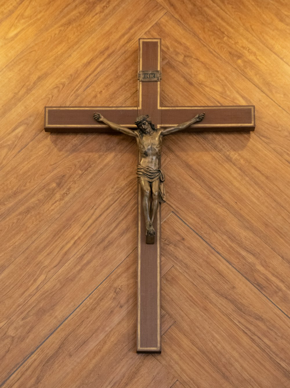 silver crucifix on brown wooden table