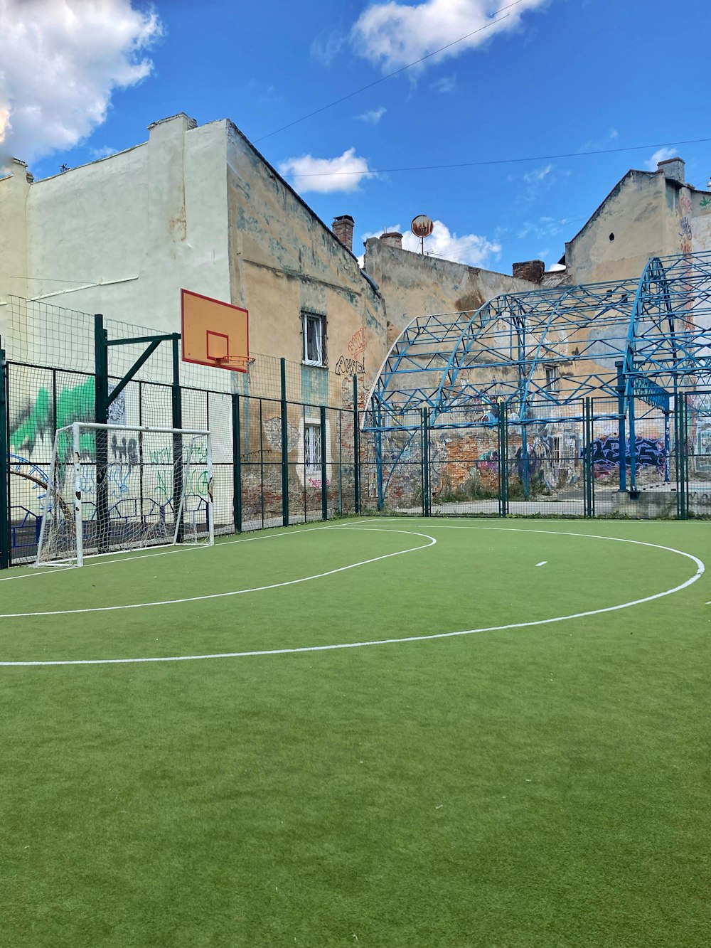 green soccer field near brown concrete building during daytime