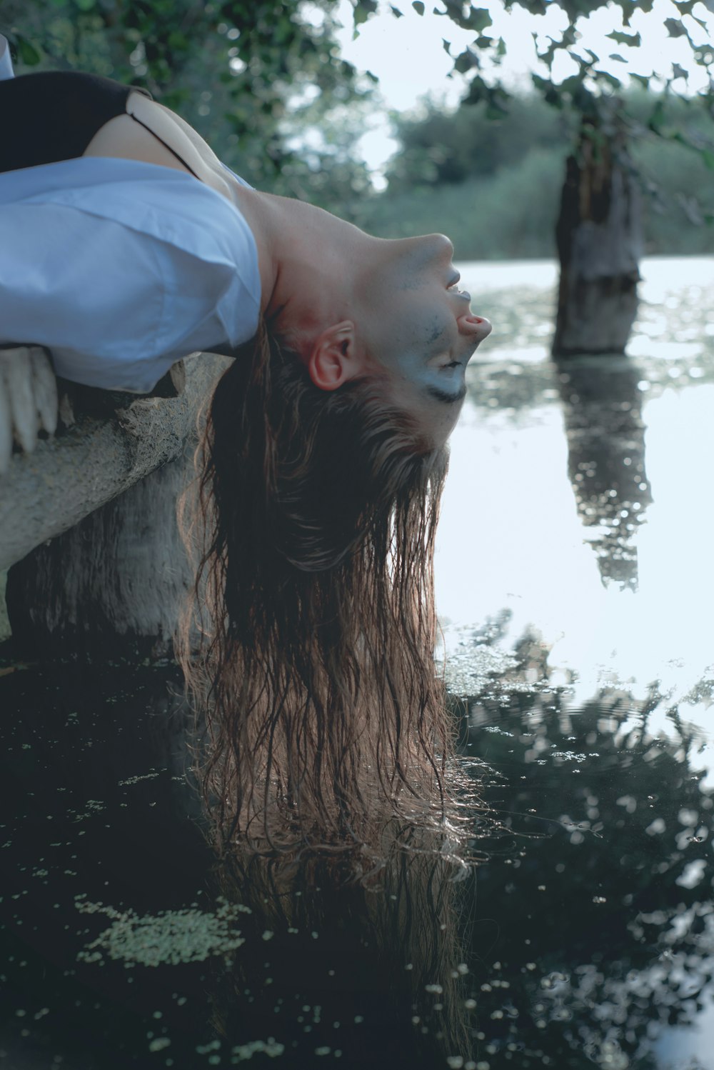 woman in white shirt standing near body of water during daytime