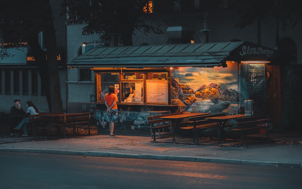 brown wooden table and chairs near store during night time