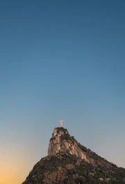 A vibrant view of Rio de Janeiro featuring Christ the Redeemer and Sugarloaf Mountain under a clear blue sky.