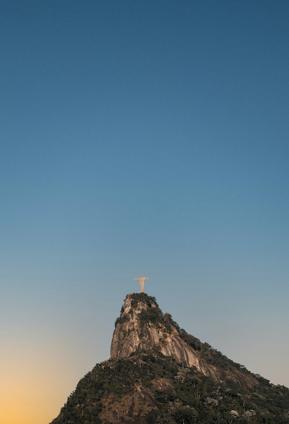 person standing on rock formation under blue sky during daytime