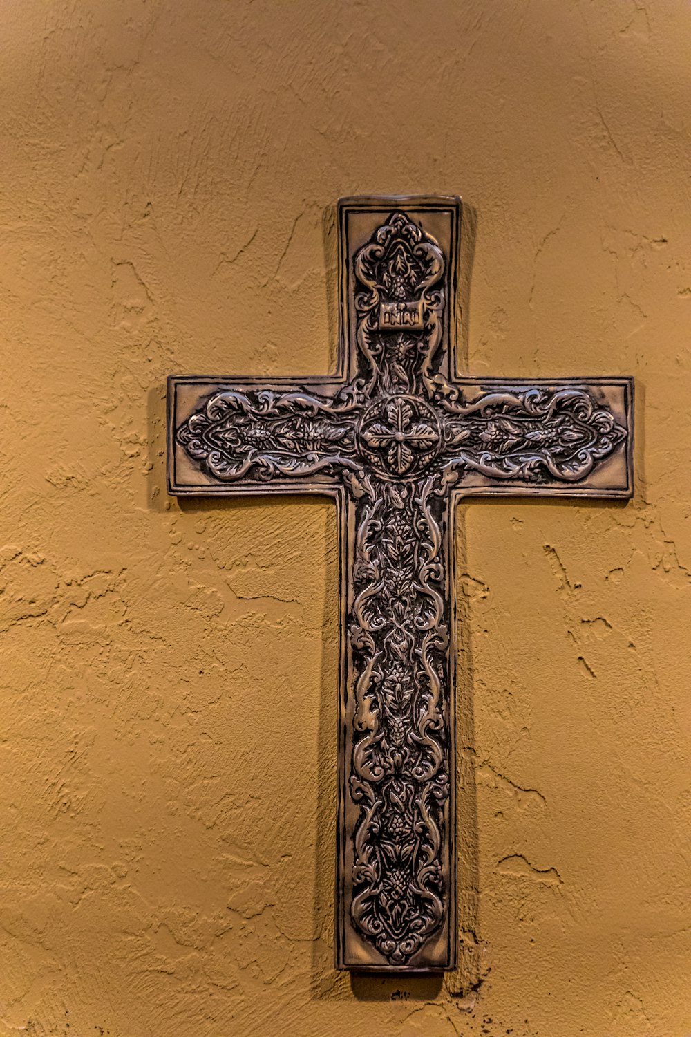 gold cross on brown wall