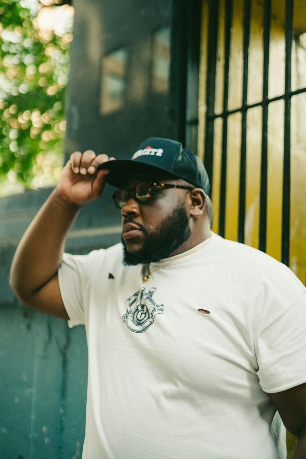 man in white crew neck t-shirt wearing black cap