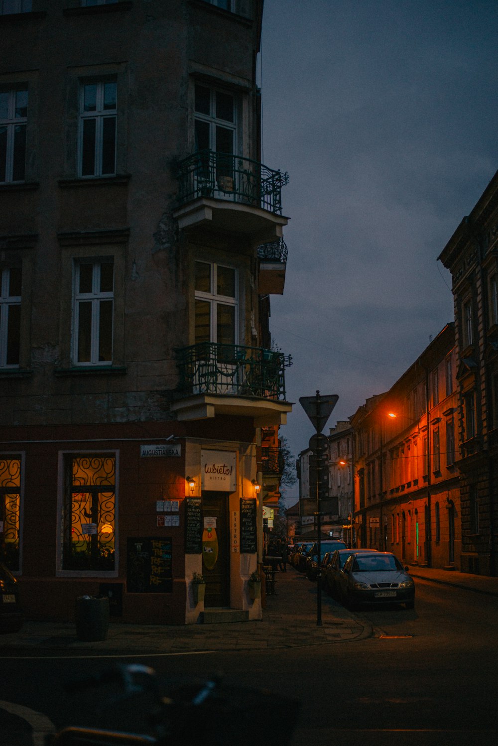 cars parked beside brown concrete building during night time