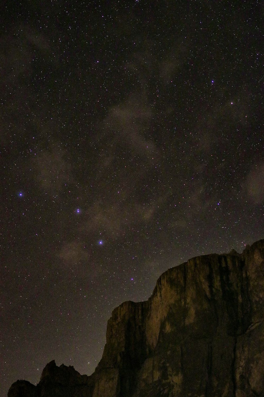 brown rocky mountain under starry night