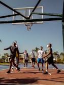 Happy hobby players shooting hoops outdoors on a sunny day, capturing the joy of the game.
