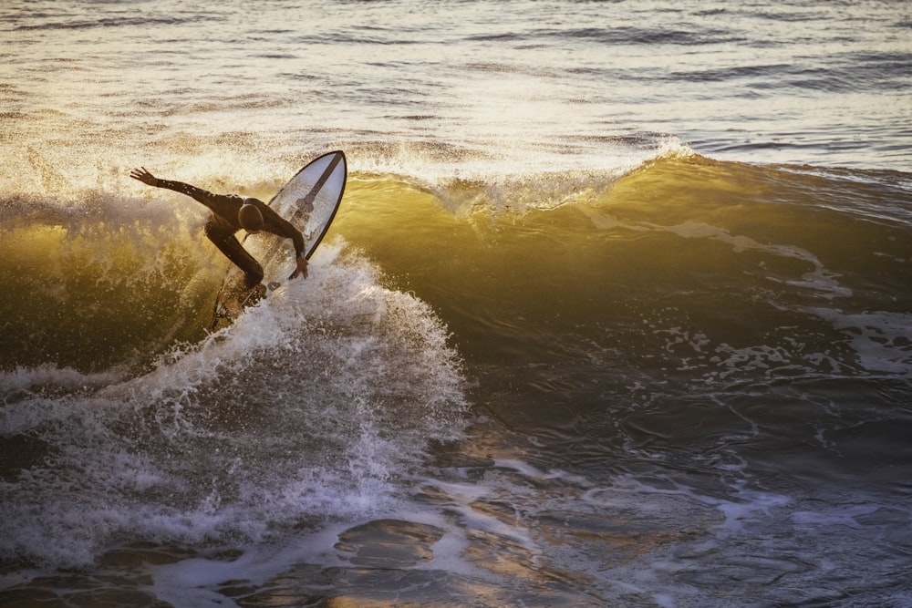 昼間、海の波でサーフィンをする男