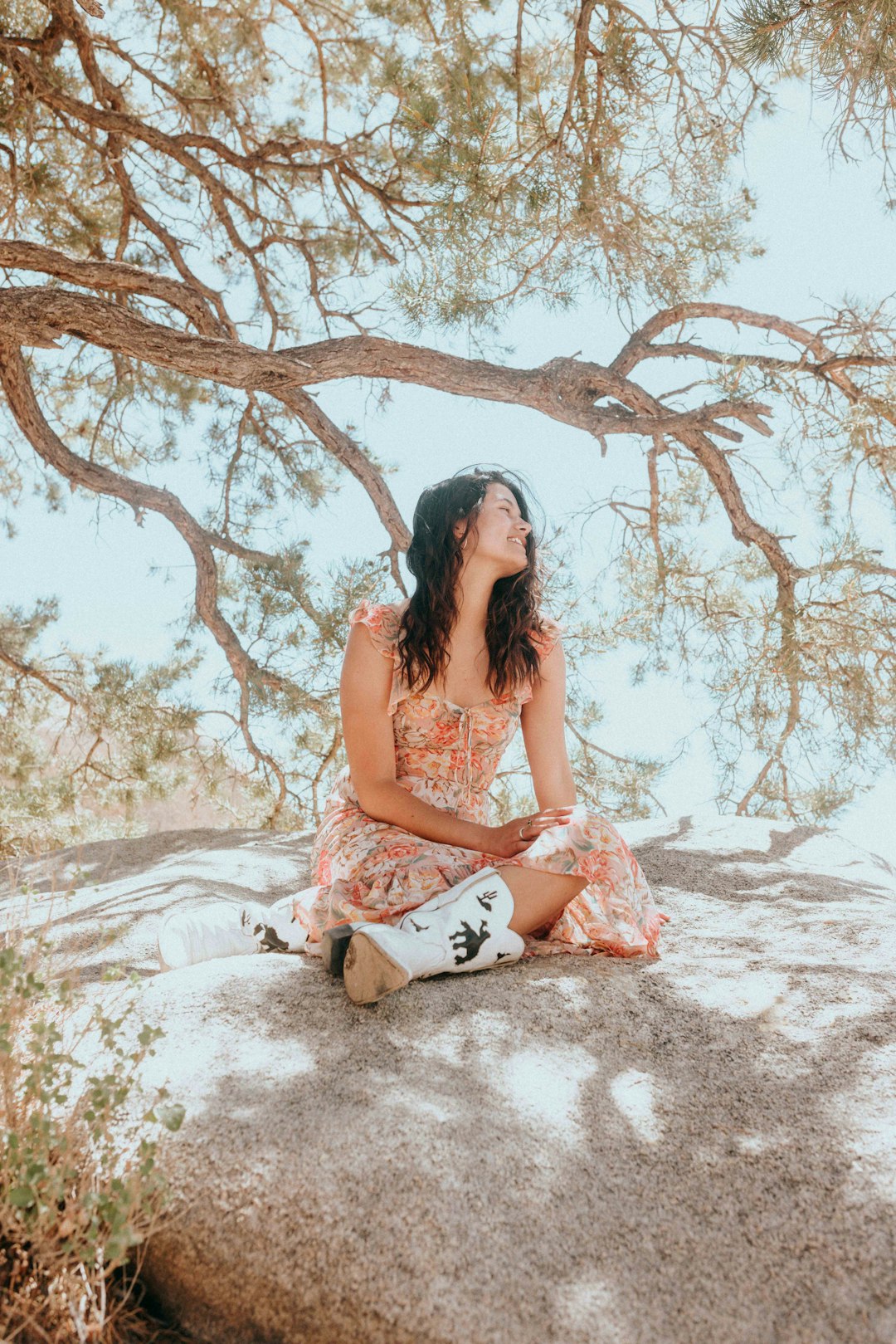 woman in red and white floral bikini sitting on white sand during daytime