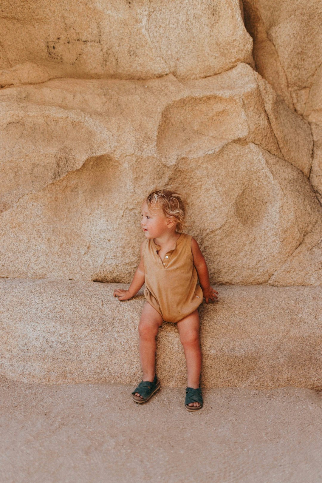 girl in brown dress sitting on brown concrete floor