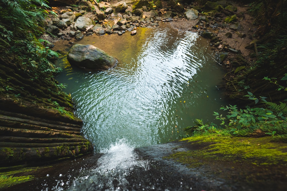 water falls on rocky shore during daytime