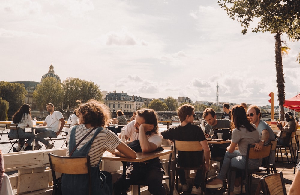 people sitting on brown wooden chairs during daytime