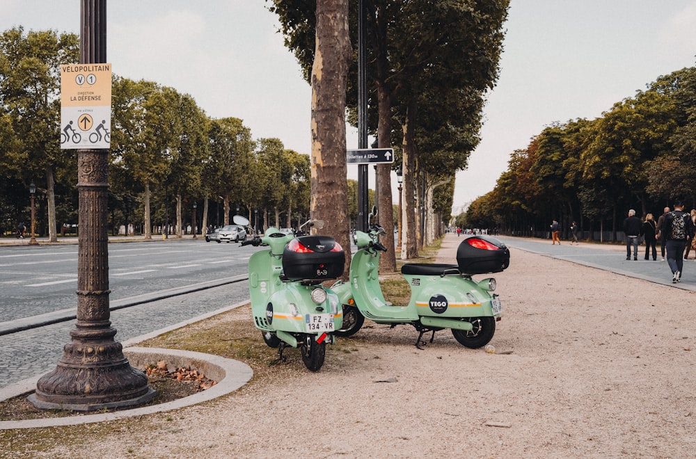 scooter motor verde estacionada no lado da estrada durante o dia