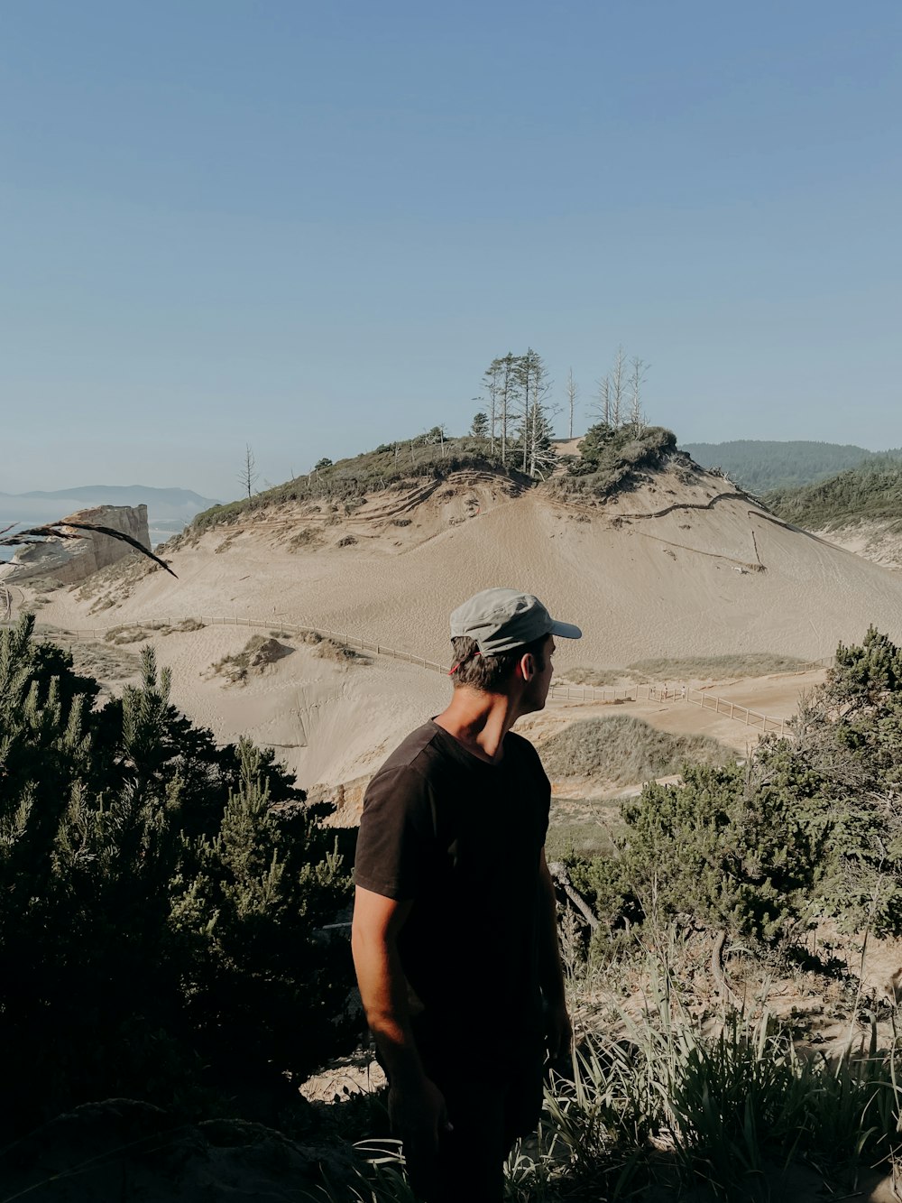 man in black t-shirt wearing black helmet standing on brown field during daytime