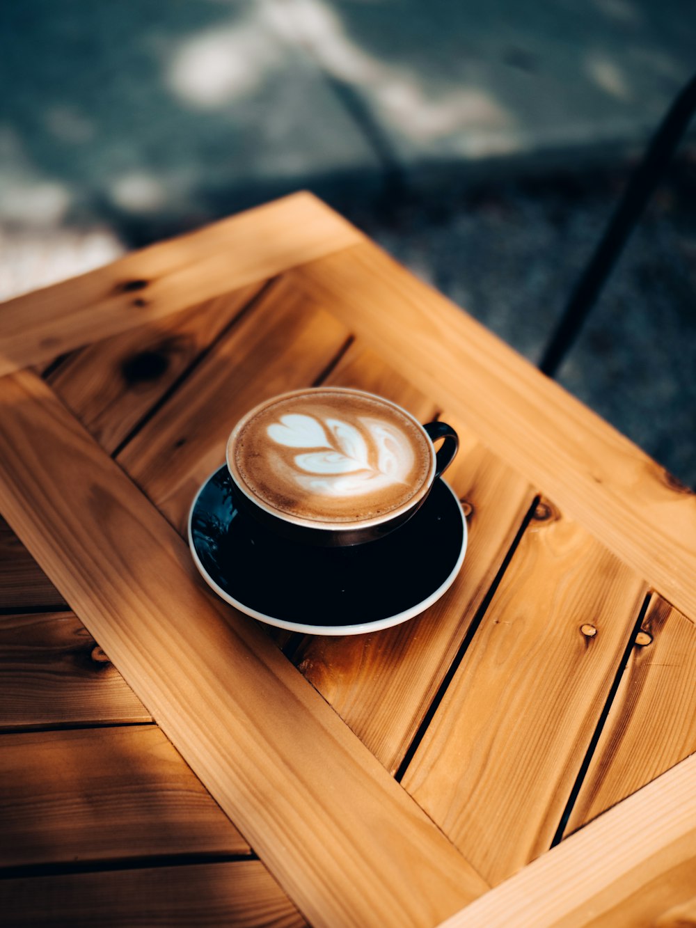 black ceramic cup on brown wooden table