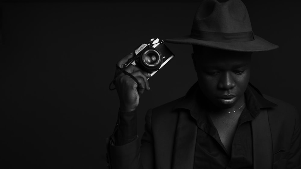 a man in a hat holding a camera
