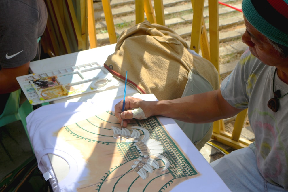 person in white shirt writing on white paper