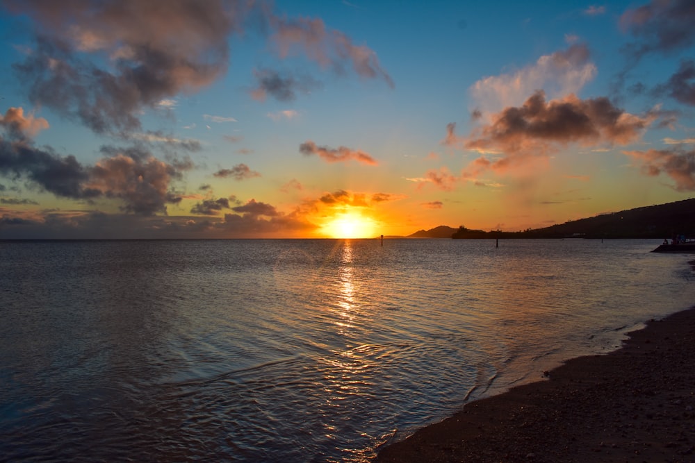 body of water under blue sky during sunset