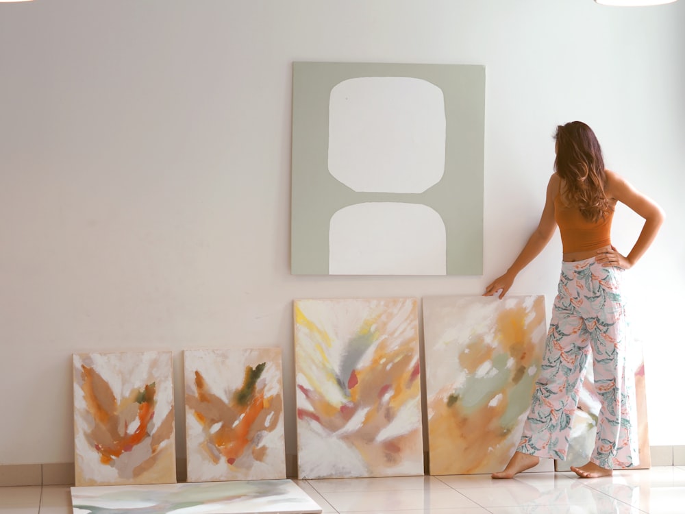 woman in white and yellow floral dress standing in front of white wall