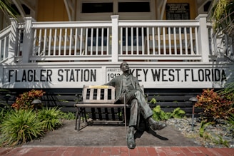 man sitting on bench statue