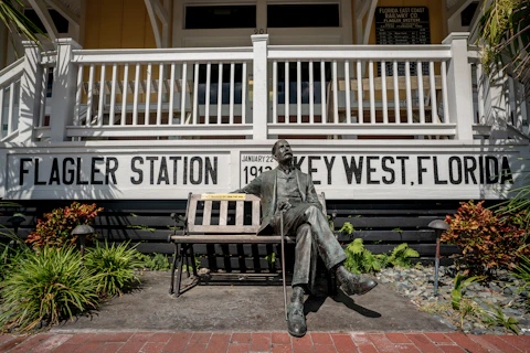 statue of a man on a bench in front of a building in key west florida