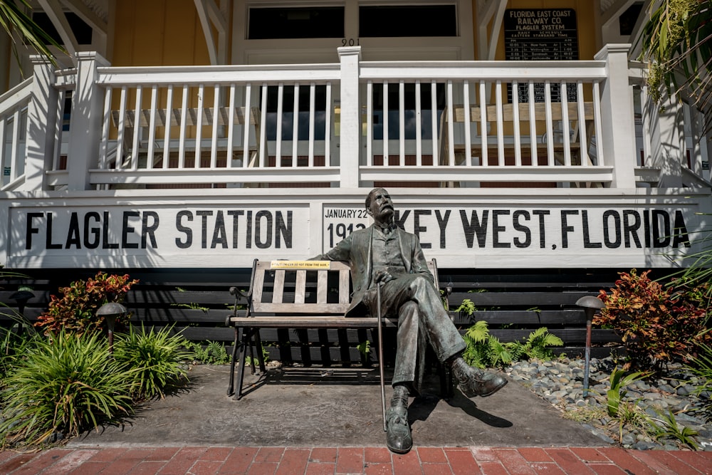 man sitting on bench statue