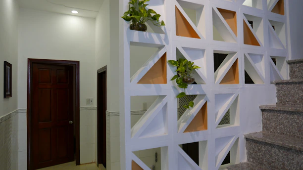 A cozy living room featuring a stylish wooden partition wall with intricate patterns softly dividing the space.
