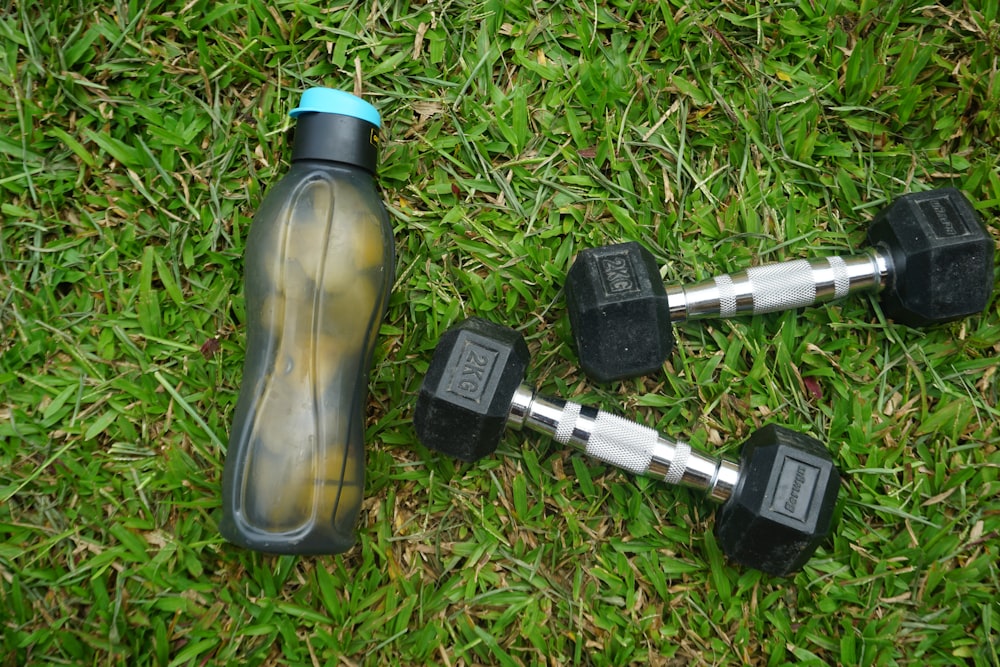 2 black and gray dumbbells on green grass