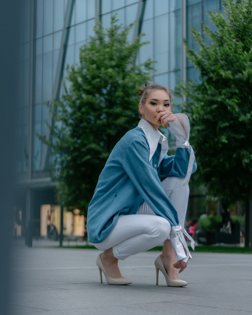 homme en blazer bleu et pantalon blanc assis sur un banc en béton