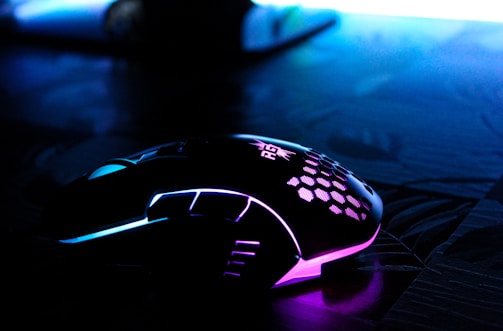 Wireless gaming mouse displayed on a modern desk with blue lighting.
