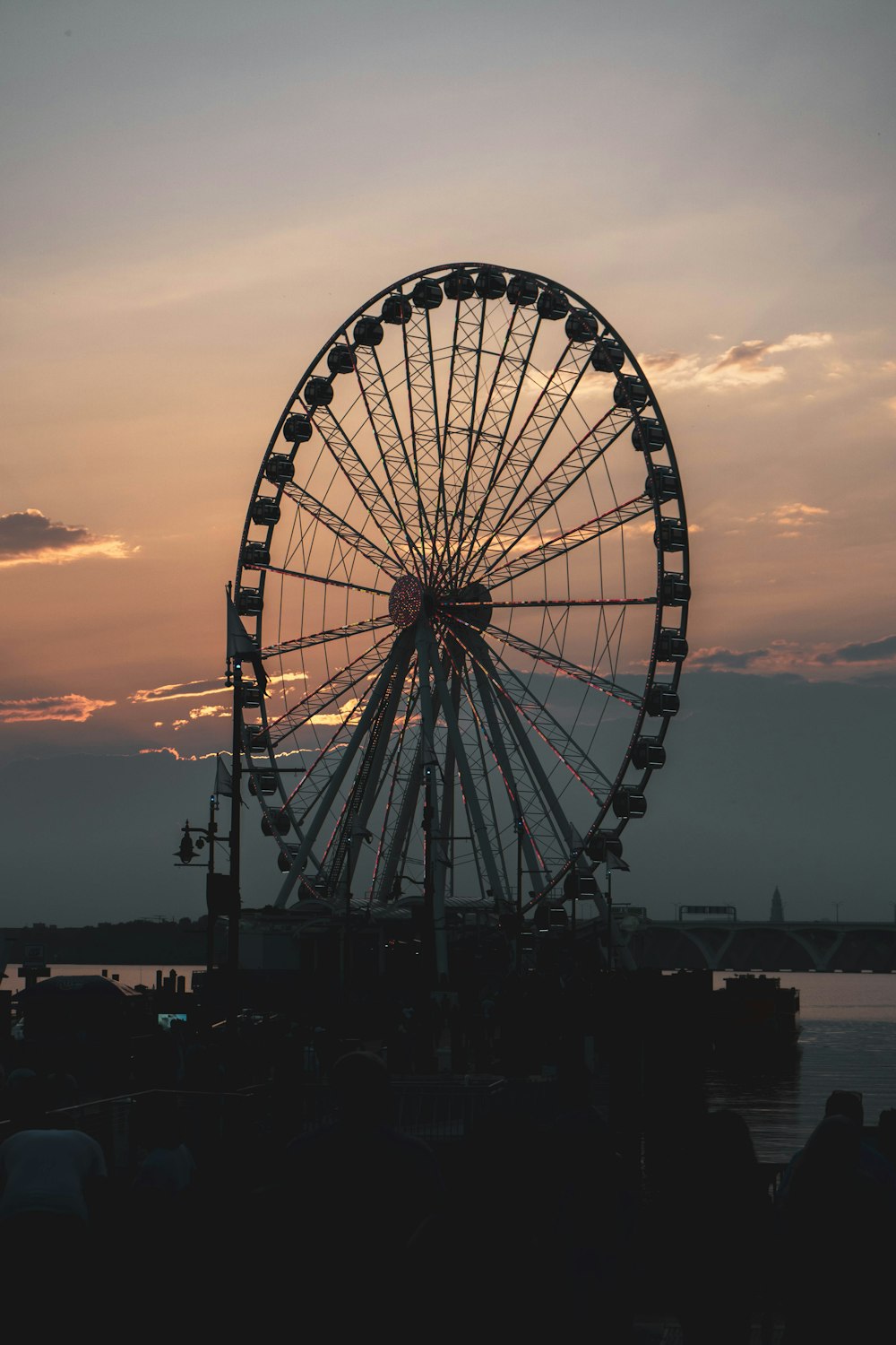 ferris wheel near body of water during sunset