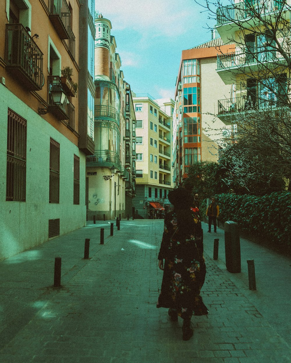 Frau im schwarzen Kittel geht tagsüber auf dem Bürgersteig spazieren