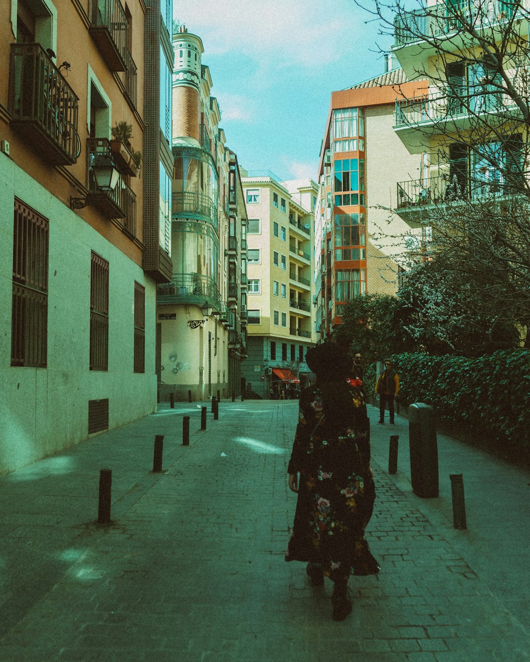 woman in black coat walking on sidewalk during daytime